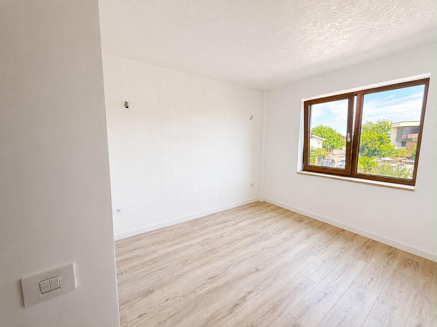 Dormitor luminos cu fereastră mare spre stradă