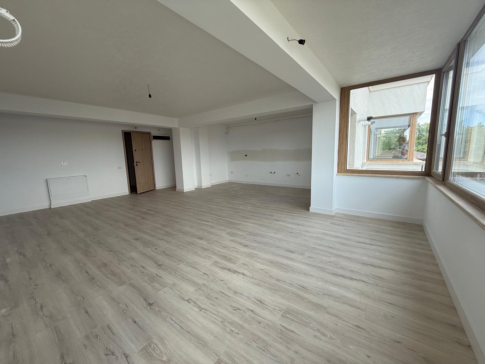 Living de colț cu ferestre panoramice din lemn, parchet deschis și grindă structurală