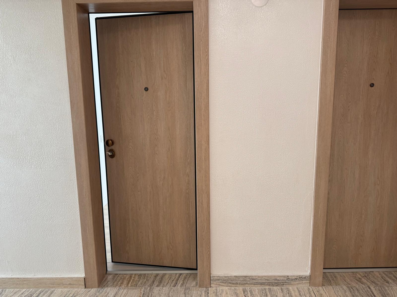 Zonă de tranzit open-space spre living, pereți albi minimaliști și parchet continuu
