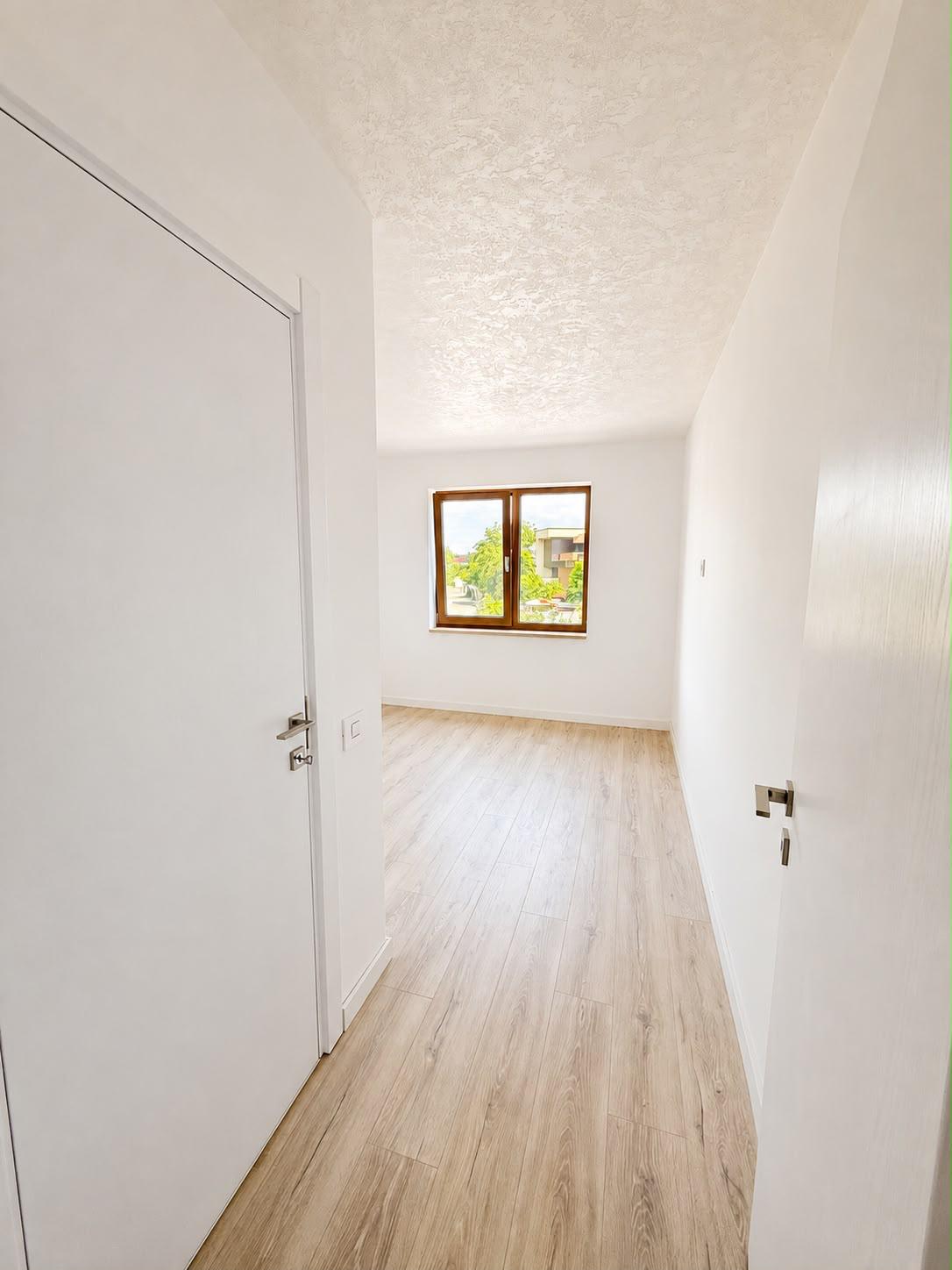 Vedere dinspre hol spre cameră cu uși albe moderne