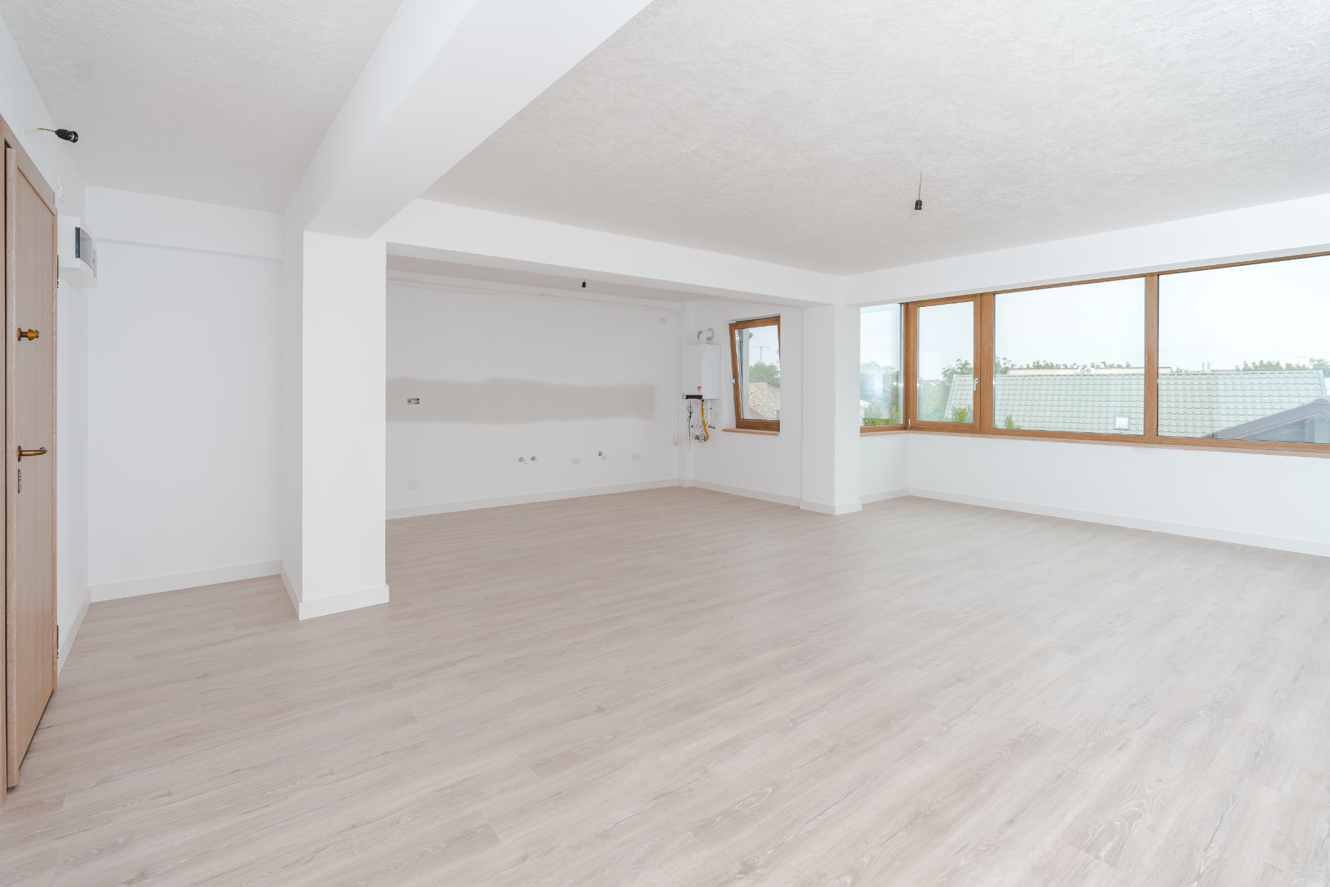 Living open-space cu ferestre mari din lemn și grindă aparentă