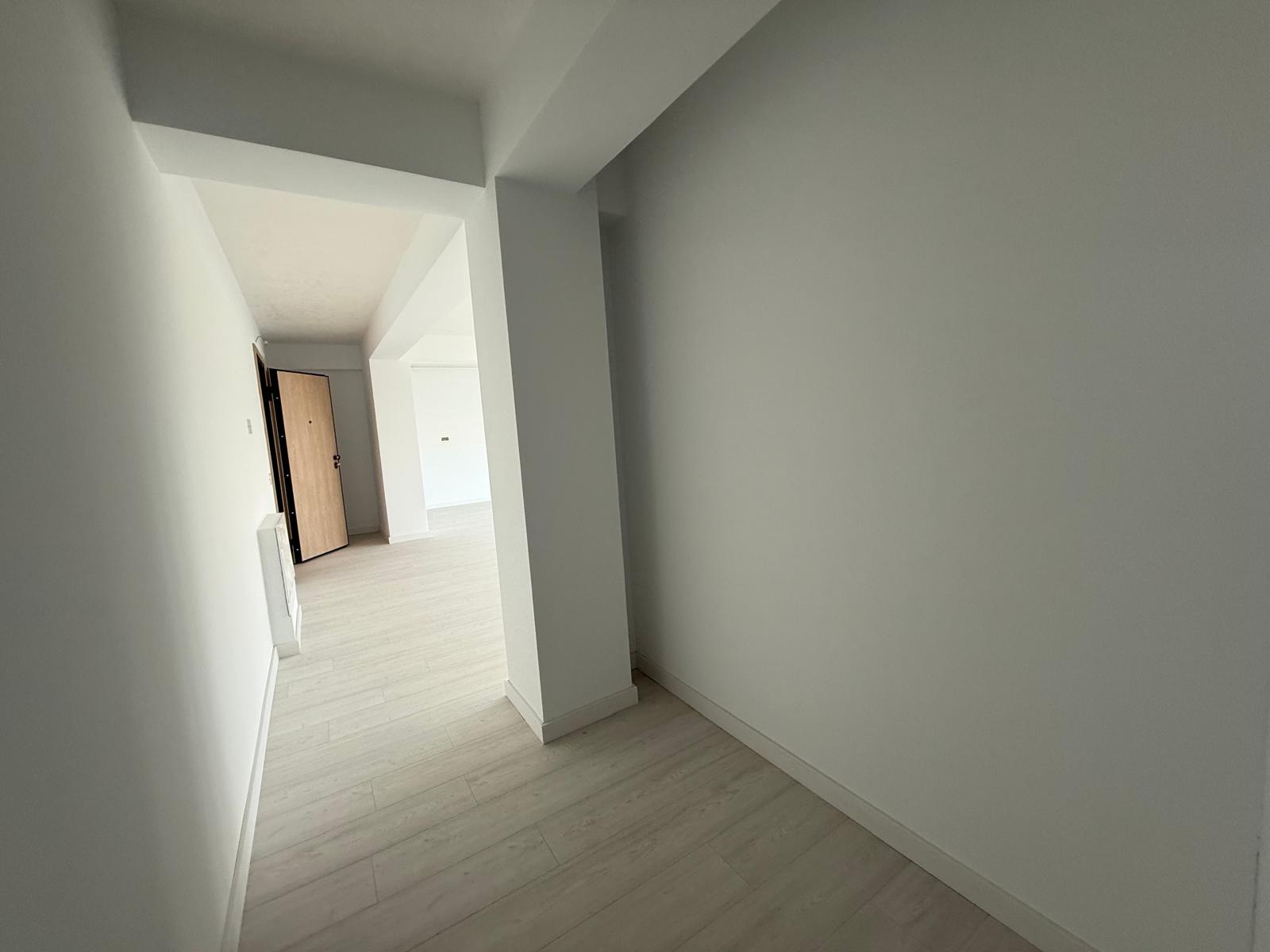 Hol de acces cu stâlp structural și trecere spre zona de zi