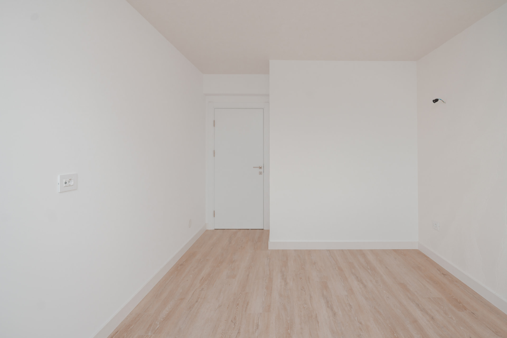 Cameră minimalistă cu finisaje moderne și pardoseală de lemn
