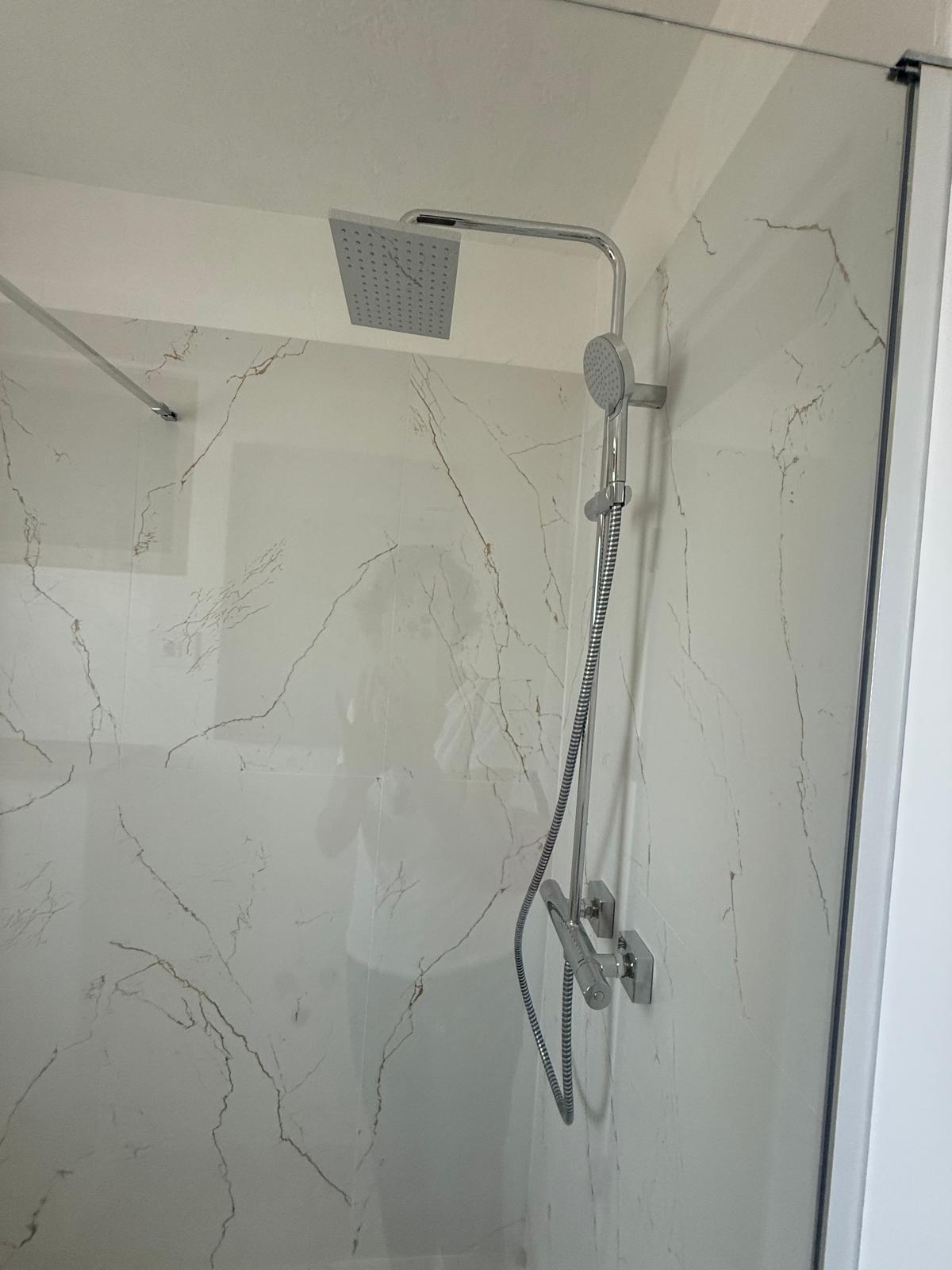 Intrare baie cu duș walk-in și zona vanitas, ușă albă cu mâner cromat