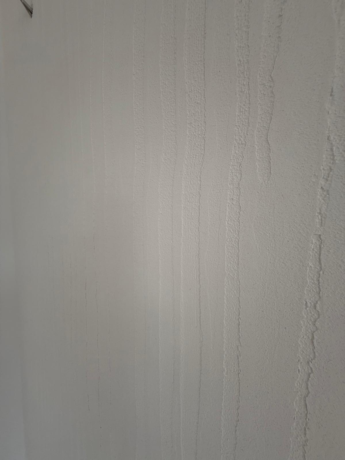 Detaliu finisaj perete cu textură verticală din tencuială decorativă