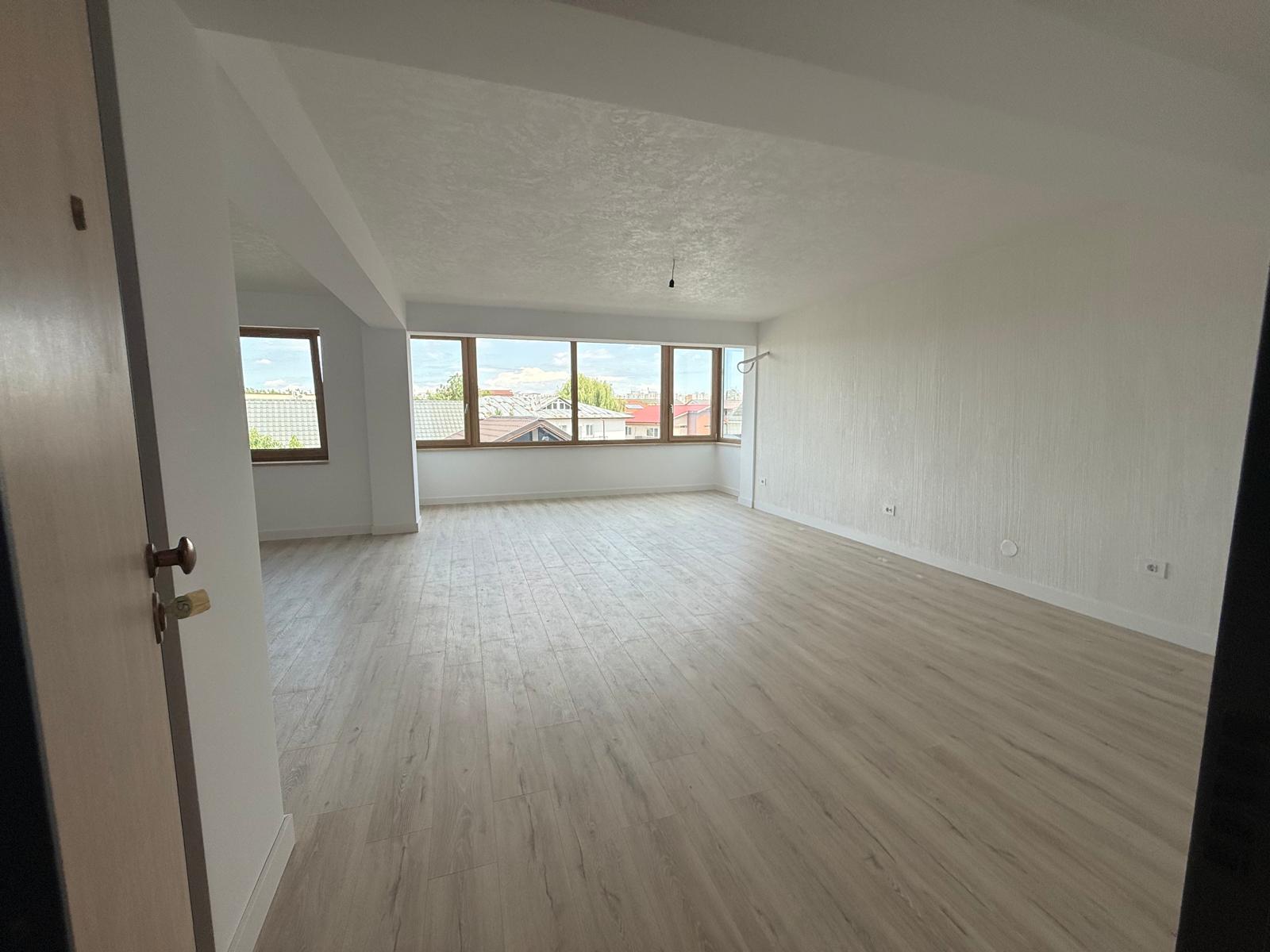 Living spațios cu ferestre panoramice din lemn, parchet deschis și tavan cu grindă aparentă